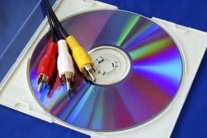 Three-color RCA video cables on a CD isolated on blue