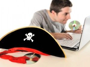 Pirate hat and Young man  copying disk with computer
