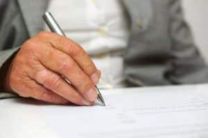 older woman signing the document