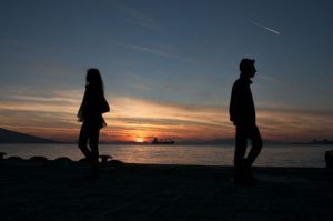 2 people by the water at sunset