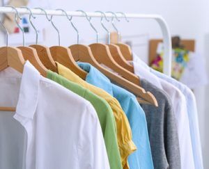 Clothes hang on a shelf in  designer clothes store