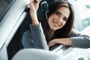 Woman Driver Holding Car Keys siting in Her New Car.