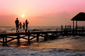 Family walking on a pier at sunset